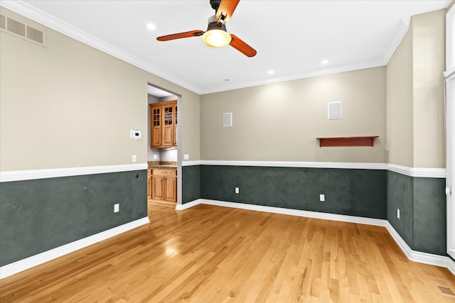 empty room with ceiling fan, light wood-type flooring, and crown molding