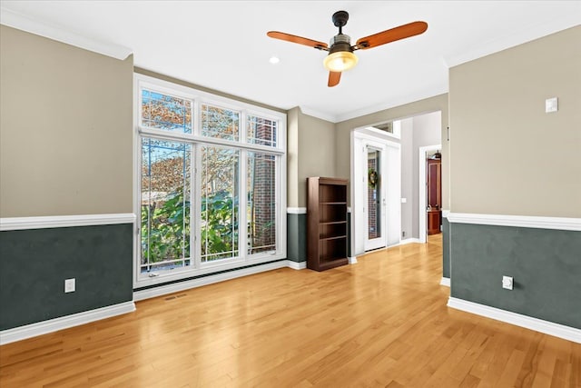 spare room featuring ceiling fan, crown molding, and light hardwood / wood-style flooring