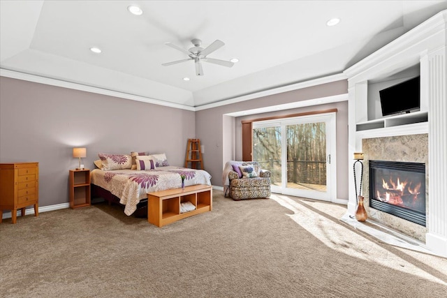 bedroom with access to exterior, carpet floors, ceiling fan, and a premium fireplace