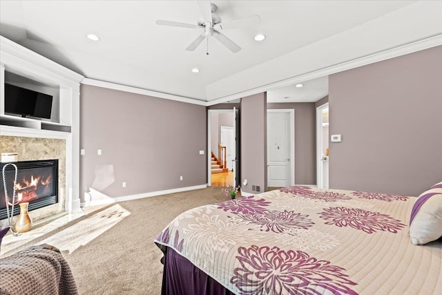 bedroom with carpet, ceiling fan, ornamental molding, and a high end fireplace