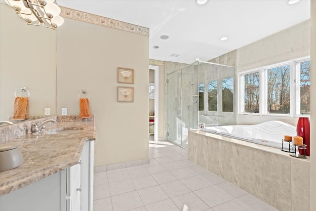 bathroom with plus walk in shower, vanity, an inviting chandelier, and tile patterned flooring