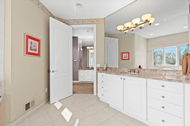 bathroom featuring tile patterned flooring, vanity, and a notable chandelier