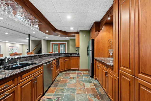 kitchen with dark stone countertops, sink, and appliances with stainless steel finishes