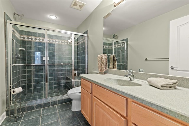 bathroom with tile patterned floors, vanity, an enclosed shower, and toilet