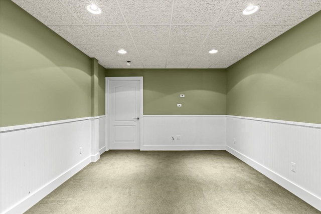 spare room with light carpet and a drop ceiling