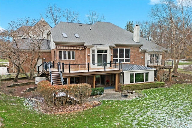 rear view of property with a deck and a yard