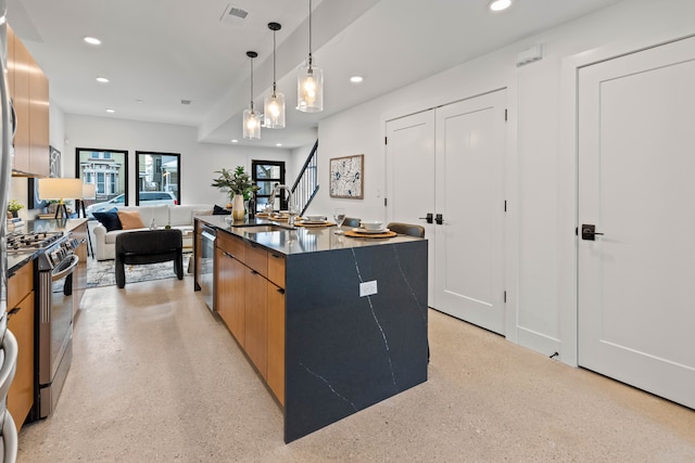 kitchen with gas stove, sink, dishwasher, pendant lighting, and a center island