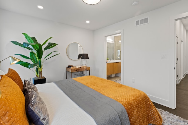 bedroom featuring dark hardwood / wood-style flooring and connected bathroom