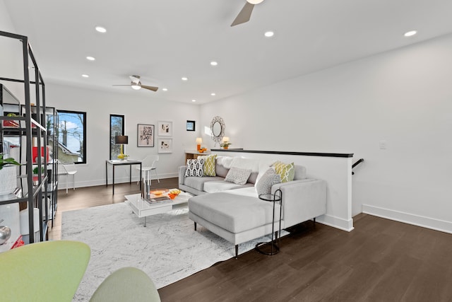 living room featuring dark wood-type flooring and ceiling fan