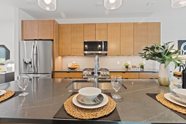 kitchen with backsplash and appliances with stainless steel finishes