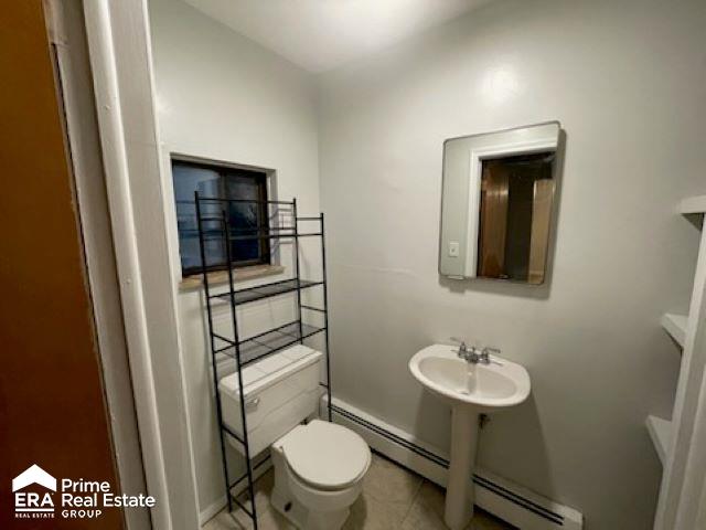 bathroom with toilet, baseboard heating, and sink