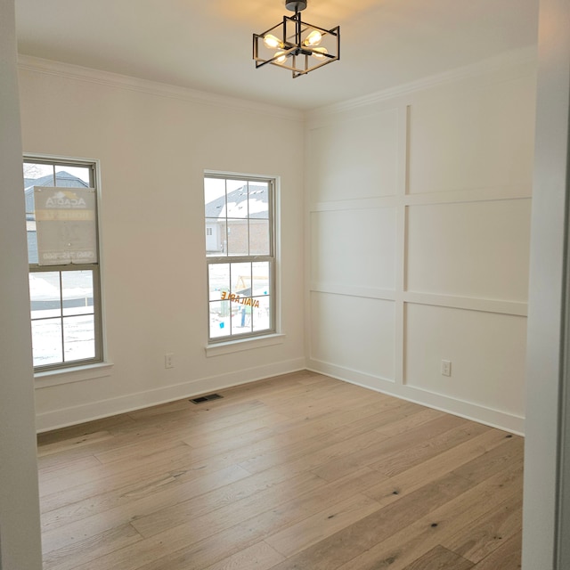 unfurnished dining area featuring plenty of natural light, light hardwood / wood-style flooring, ornamental molding, and a chandelier