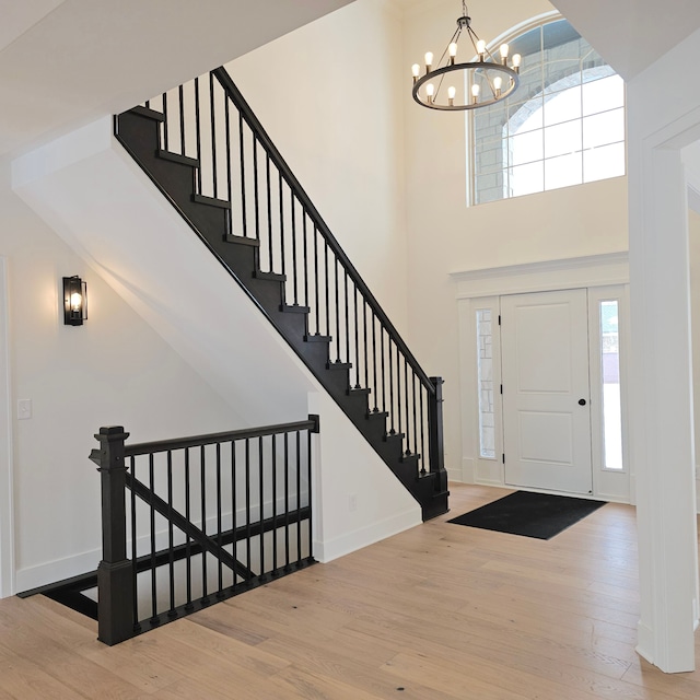 entrance foyer featuring an inviting chandelier, a wealth of natural light, and wood-type flooring