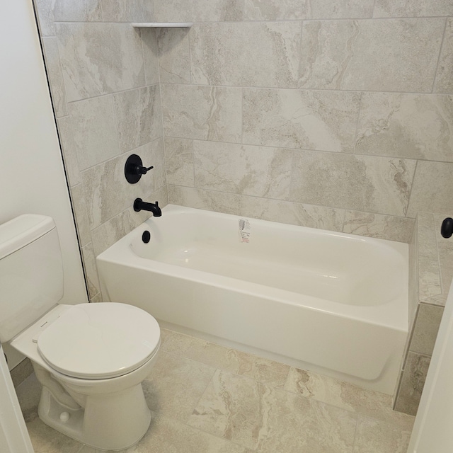 bathroom with toilet and tiled shower / bath combo