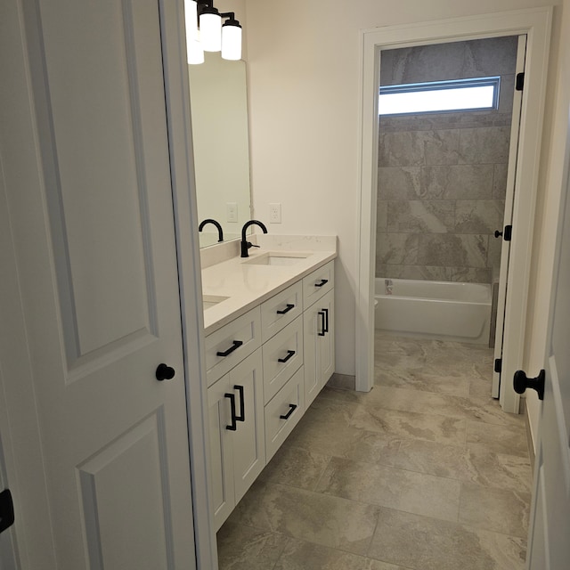 bathroom featuring tiled shower / bath combo and vanity