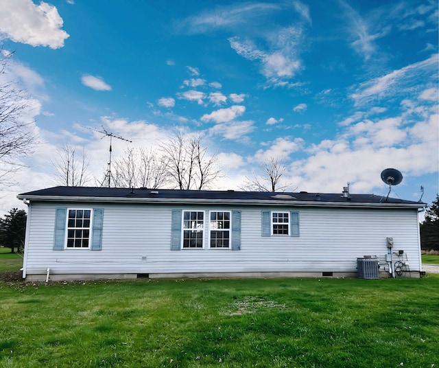 back of property featuring cooling unit and a yard