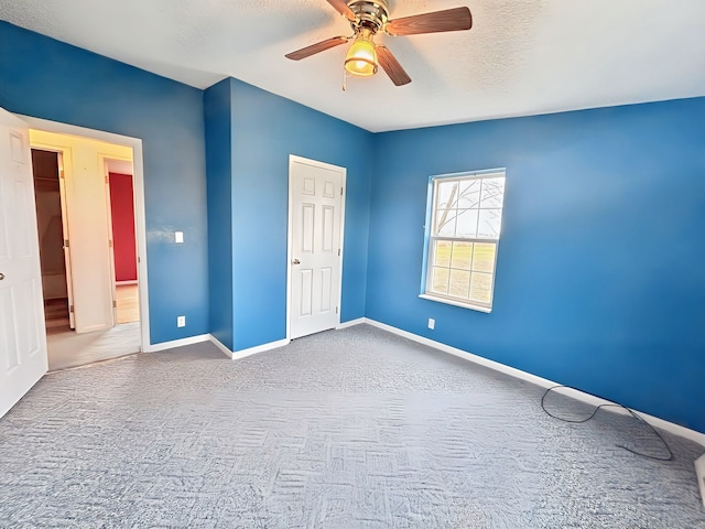 unfurnished bedroom with carpet, ceiling fan, and a textured ceiling