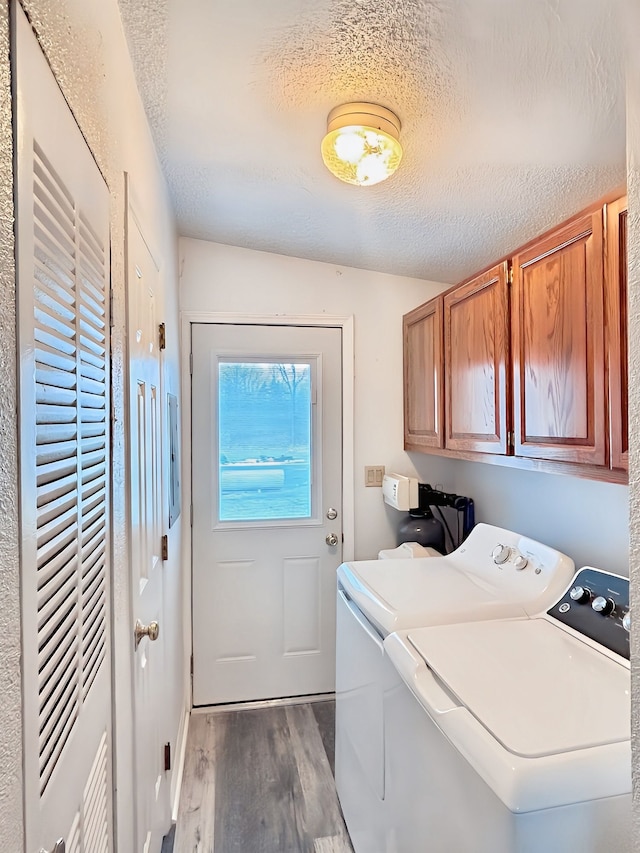 laundry area with cabinets, independent washer and dryer, a textured ceiling, and dark wood-type flooring