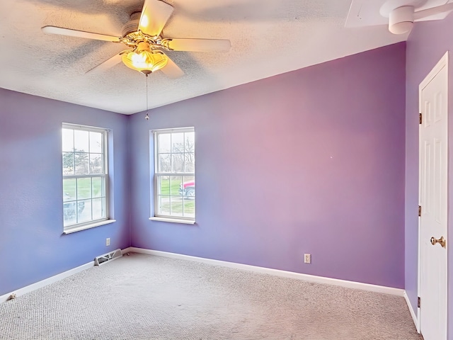 empty room featuring carpet flooring, lofted ceiling, ceiling fan, and a textured ceiling