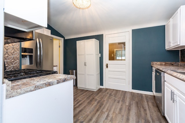 kitchen with appliances with stainless steel finishes, vaulted ceiling, white cabinetry, and hardwood / wood-style floors