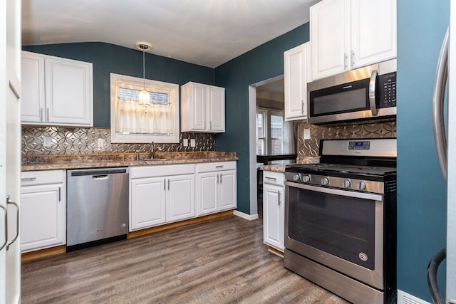 kitchen with white cabinets, sink, appliances with stainless steel finishes, decorative light fixtures, and dark hardwood / wood-style flooring