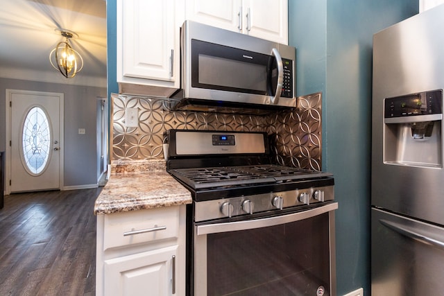 kitchen with white cabinets, light stone counters, appliances with stainless steel finishes, and tasteful backsplash