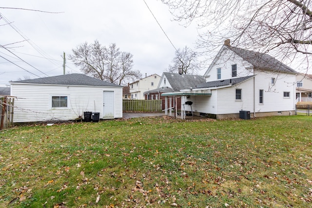 back of house with a lawn and central air condition unit