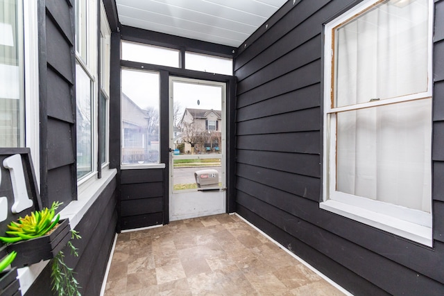 doorway featuring wooden walls