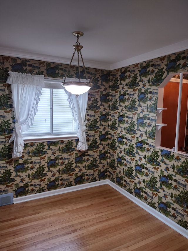 unfurnished dining area featuring crown molding and hardwood / wood-style floors