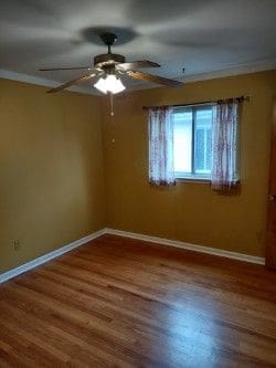 spare room with crown molding, ceiling fan, and hardwood / wood-style flooring