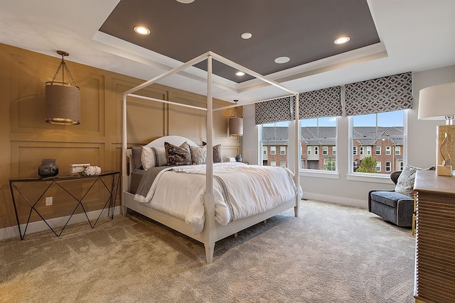 bedroom with a raised ceiling and carpet floors