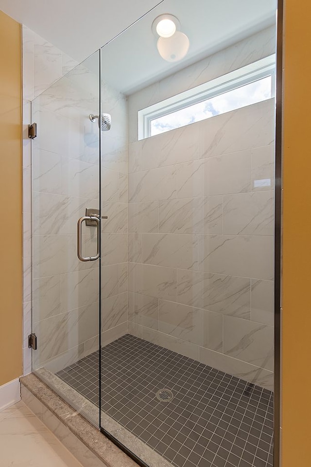 bathroom featuring a shower with door