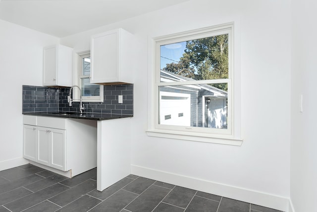 kitchen featuring white cabinets, backsplash, and sink