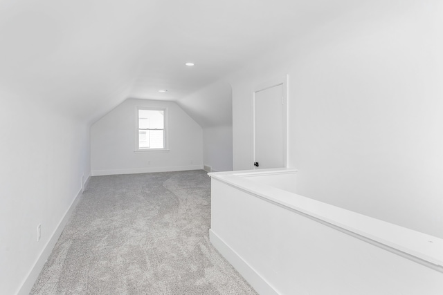 additional living space featuring light carpet and lofted ceiling