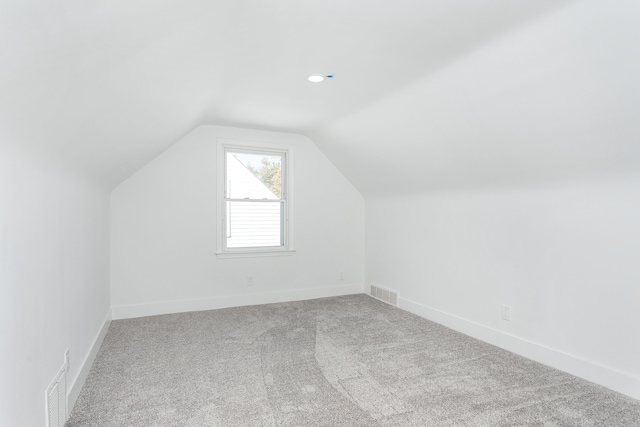 bonus room with carpet floors and vaulted ceiling