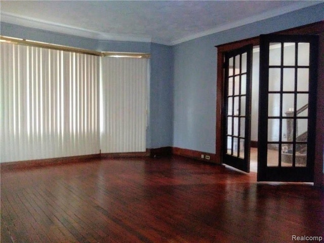 empty room featuring hardwood / wood-style floors, ornamental molding, and french doors