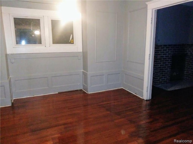 empty room with a fireplace and dark hardwood / wood-style floors