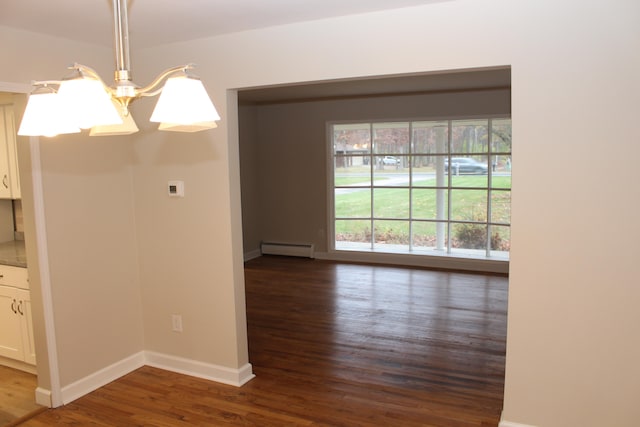 unfurnished dining area featuring baseboard heating, dark wood-type flooring, and an inviting chandelier