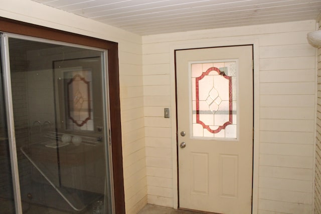 entryway featuring wooden walls