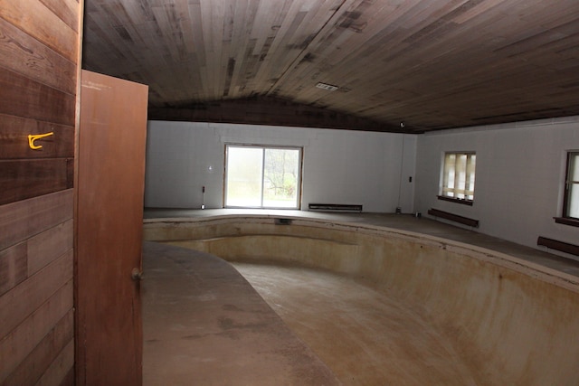 spare room with vaulted ceiling, baseboard heating, and wood ceiling