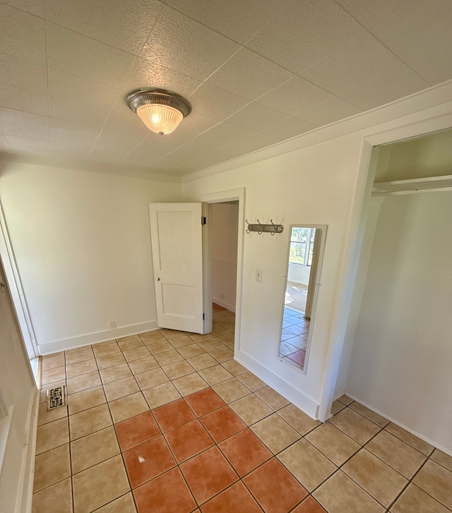 interior space with light tile patterned floors and a closet