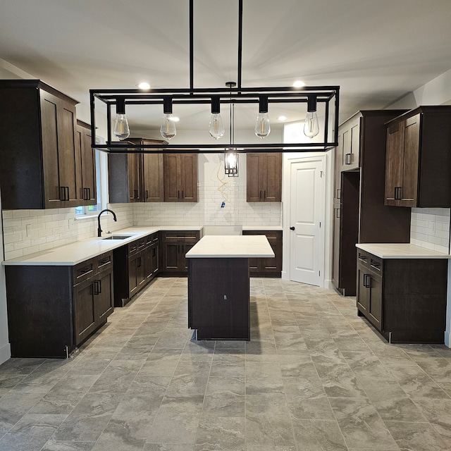 kitchen with sink, backsplash, a center island, and dark brown cabinets