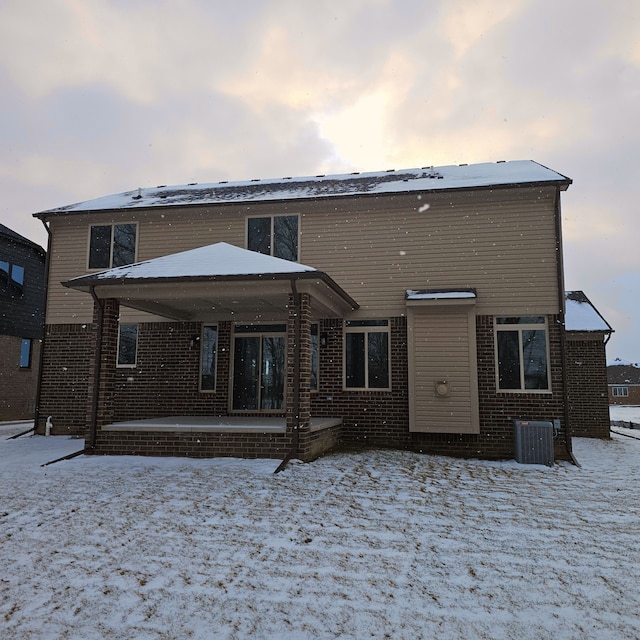 snow covered property featuring central AC