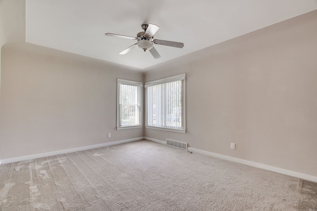 empty room featuring ceiling fan and light colored carpet