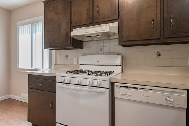 kitchen featuring backsplash, dark brown cabinets, light hardwood / wood-style flooring, and white appliances