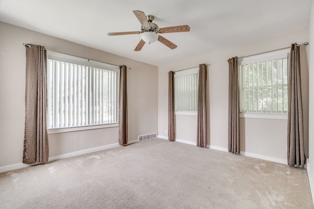 carpeted spare room with ceiling fan