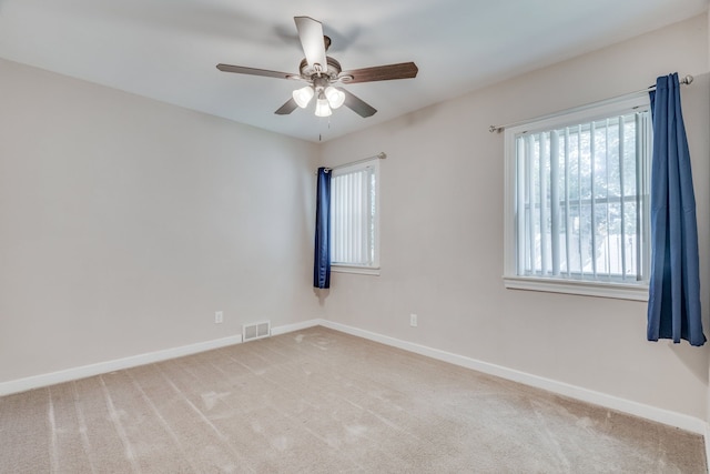 spare room with ceiling fan and light colored carpet