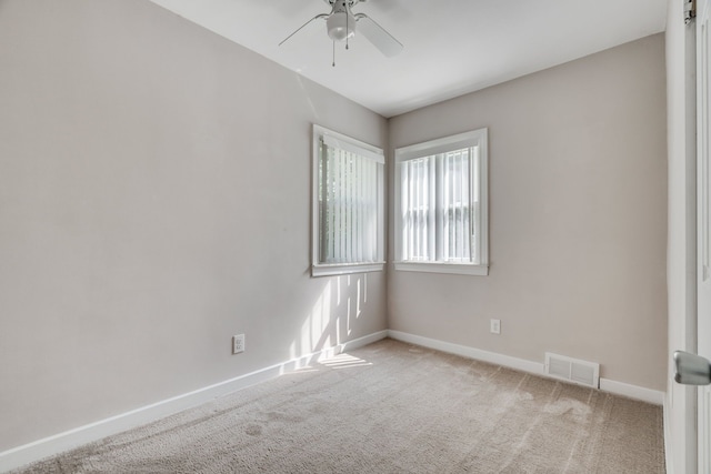 carpeted spare room featuring ceiling fan