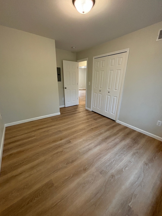 unfurnished bedroom with light wood-type flooring and a closet