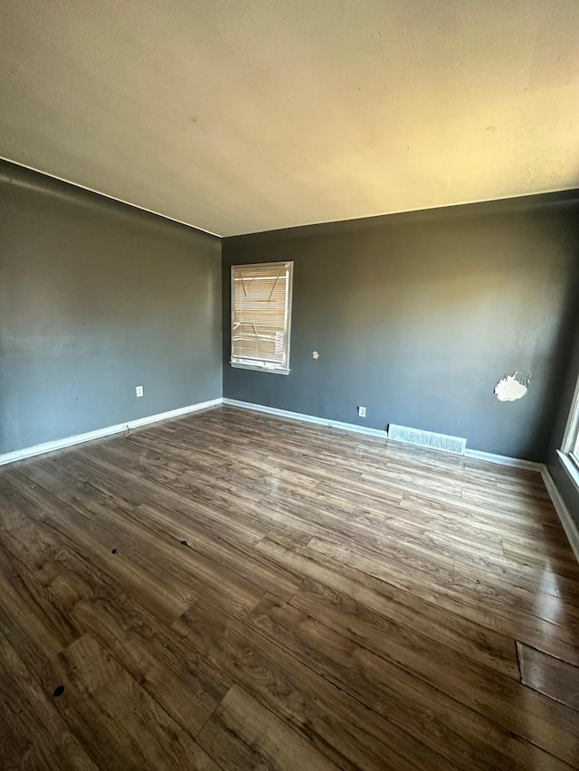 unfurnished room with dark wood-type flooring